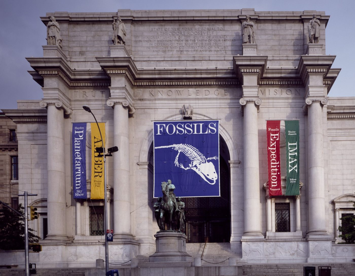 The Central Park West entrance of the American Museum of Natural History with the Theodore Roosevelt equestrian statue and banners