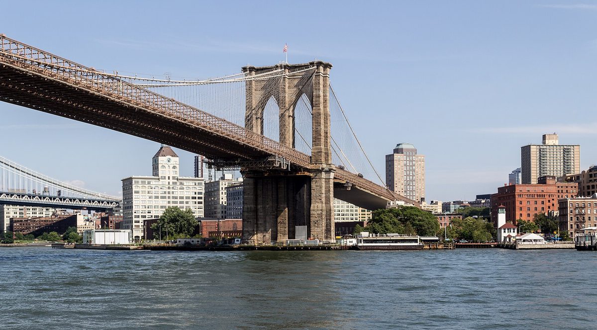 The Brooklyn Bridge and its stone tower over the East River