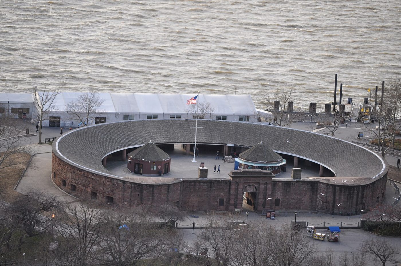 Aerial view of the circular Castle Clinton with its flat side toward Battery Park and the harbor beyond