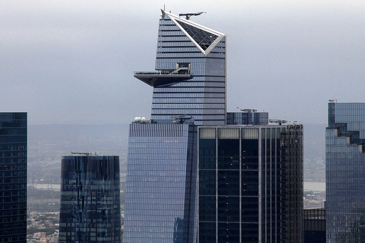 The triangular Edge sky deck jutting from the top of a glass tower at Hudson Yards, seen from a distance across Midtown