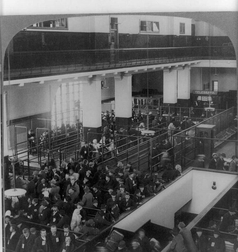 Stereograph of immigrants in the railed lanes of the Registry Room at Ellis Island in 1904