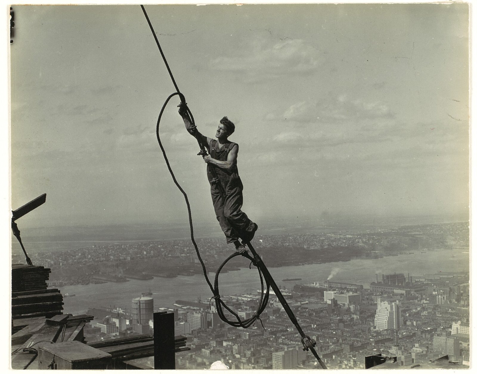 A steelworker hanging from a cable high on the Empire State Building's frame in 1930.