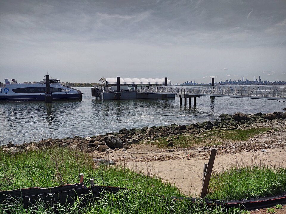 Ferry landing and the Bronx-Whitestone Bridge seen from the shore at Ferry Point Park in the Bronx