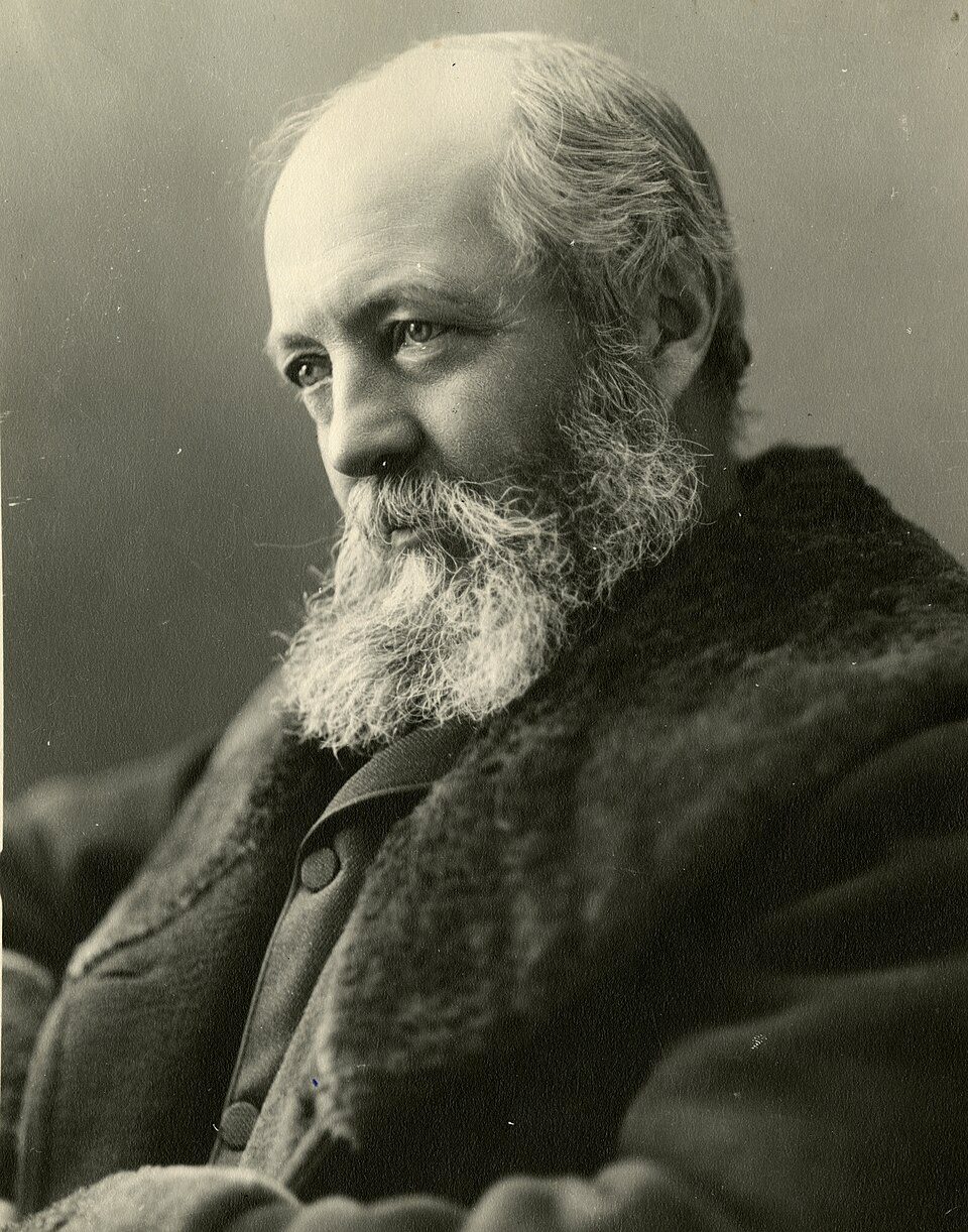 Black and white portrait photograph of Frederick Law Olmsted, an older man with a white beard in a heavy fur-collared coat