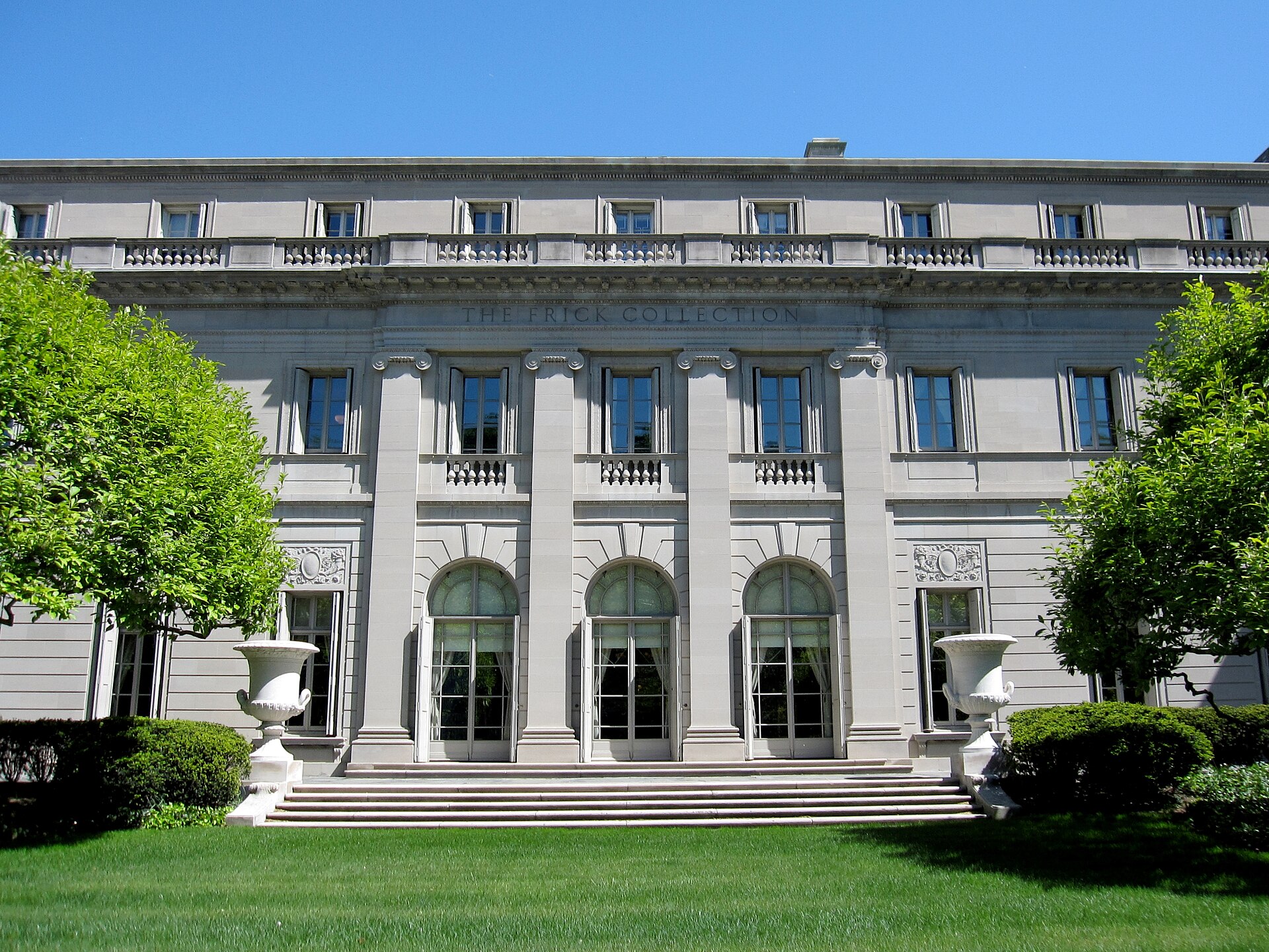 The Frick Collection mansion on Fifth Avenue, a low limestone Beaux-Arts house behind a raised lawn and retaining wall