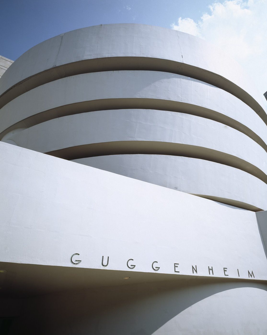 The Guggenheim name in lettering on the white curved concrete wall with the rotunda above