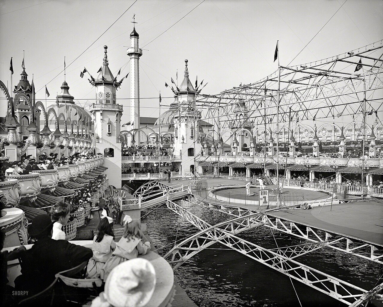 Black and white photograph of Luna Park at Coney Island with ornate white towers and crowds