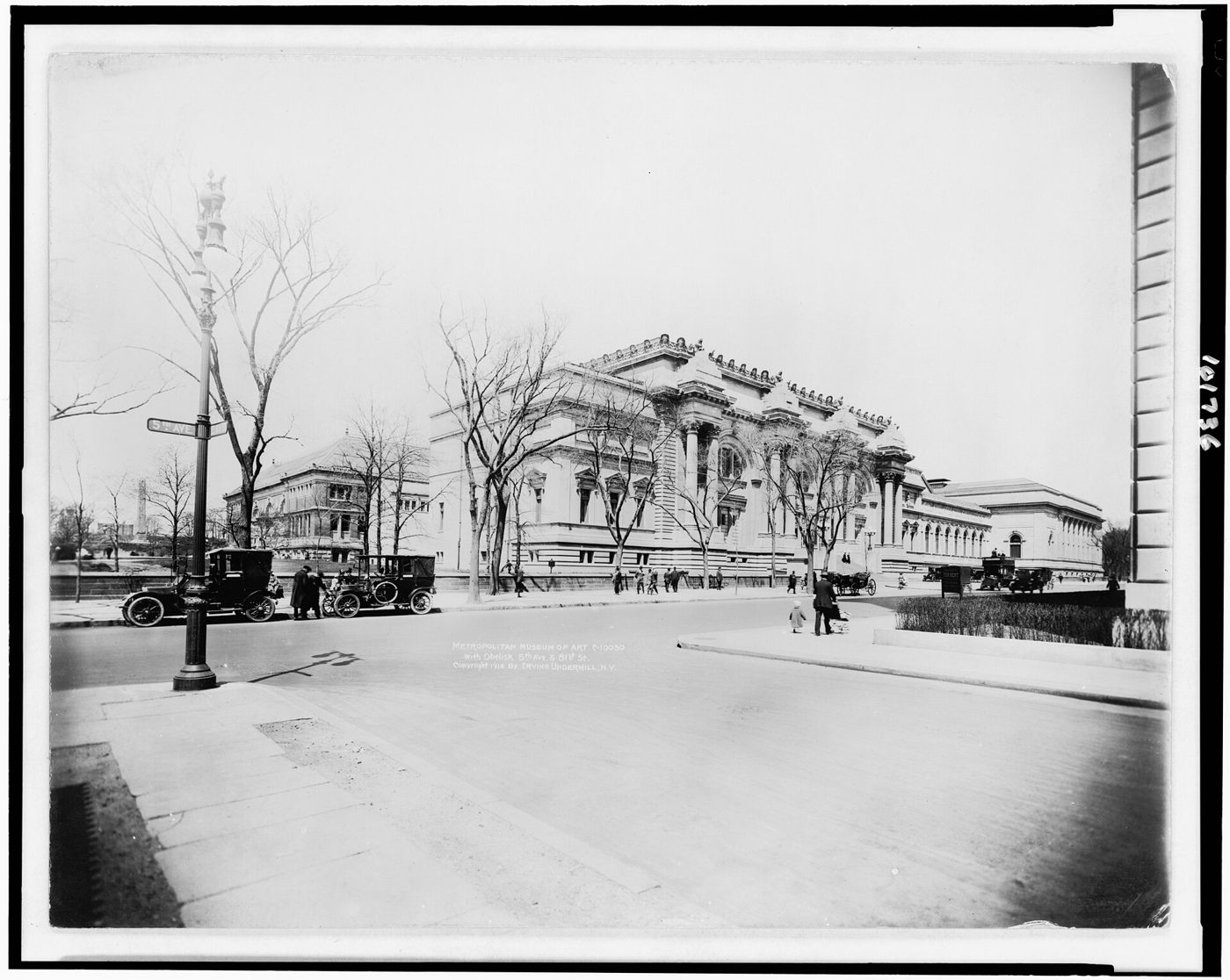 The Metropolitan Museum of Art seen across Fifth Avenue near 81st Street in an early twentieth century photograph, with a street lamp and parked cars