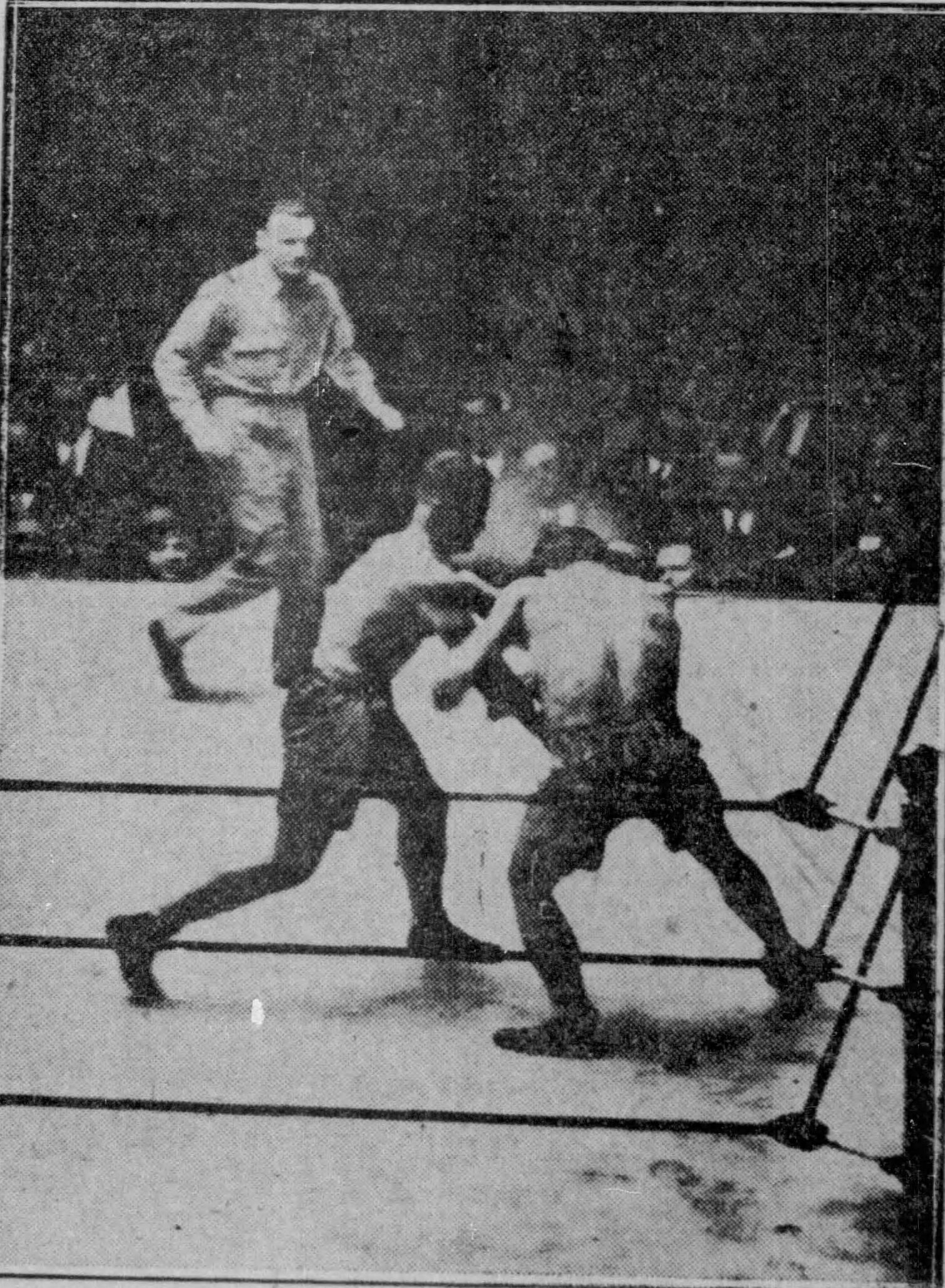A boxing match at the third Madison Square Garden in 1927, the ring lit under a darkened arena roof crowded with spectators