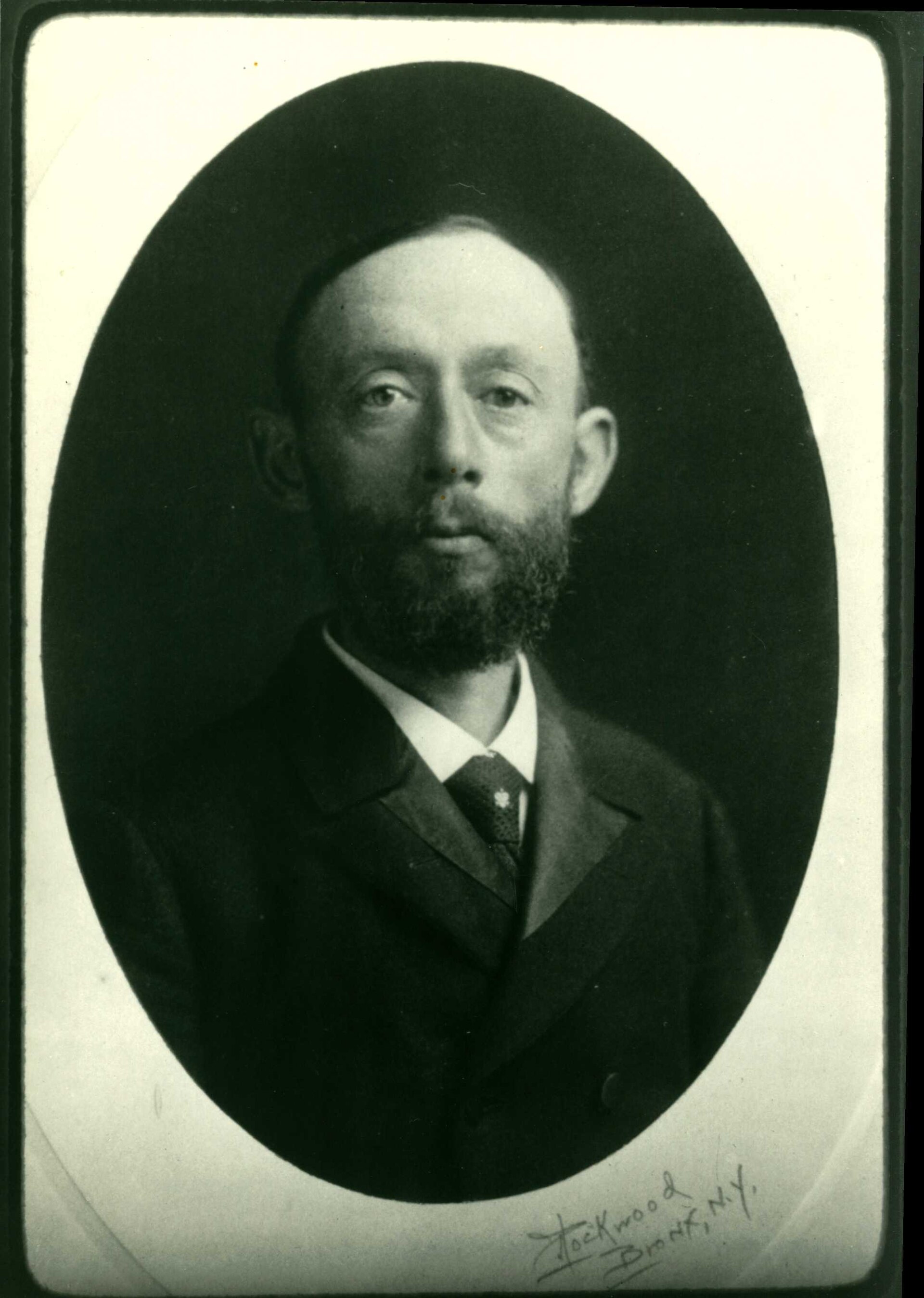 A black and white portrait photograph of Nathaniel Lord Britton, bearded, in a dark suit