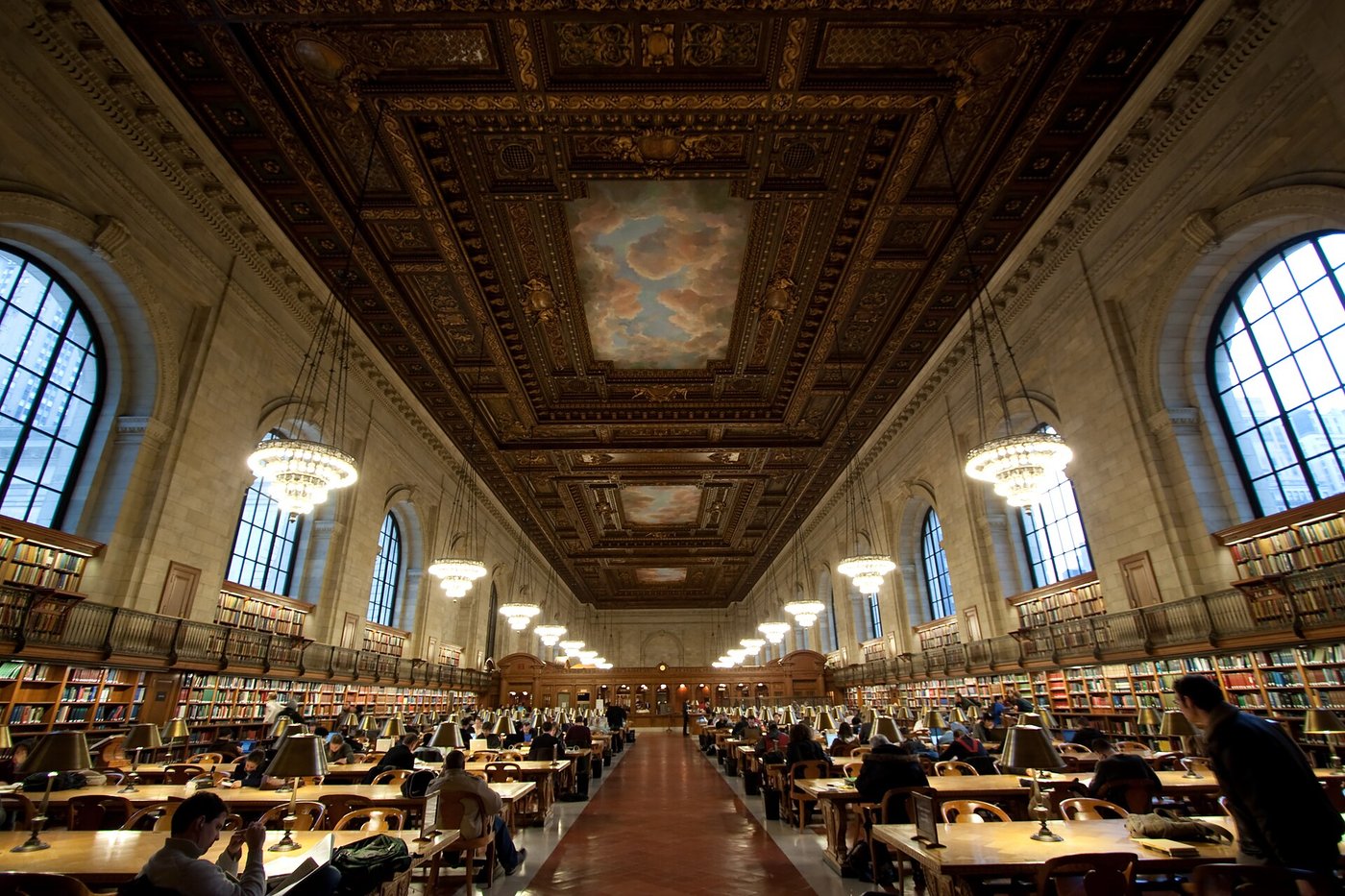 Readers at long tables in the Rose Main Reading Room under its painted ceiling.