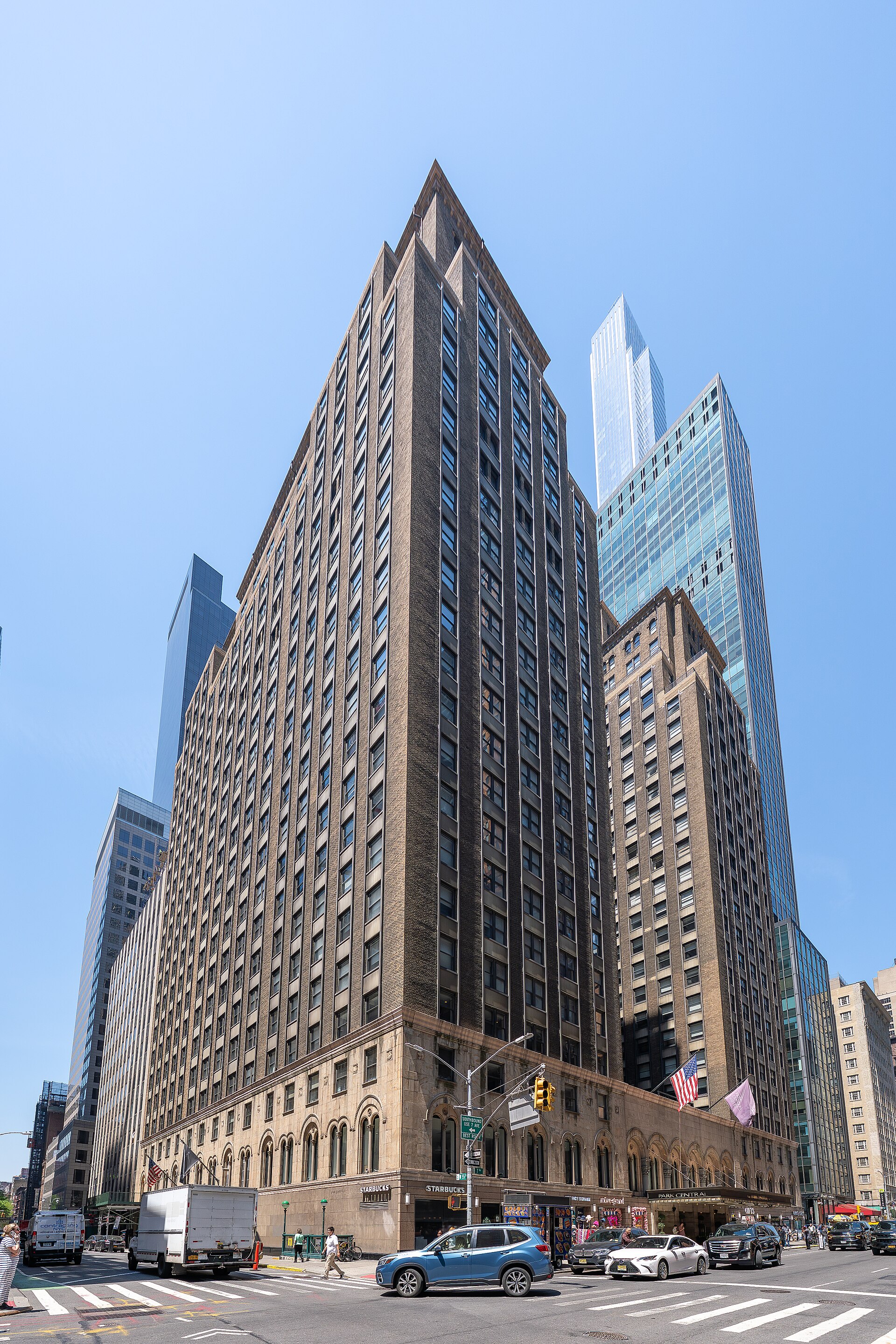 The Park Central Hotel tower rising above Seventh Avenue, a brown brick high-rise with a stone base