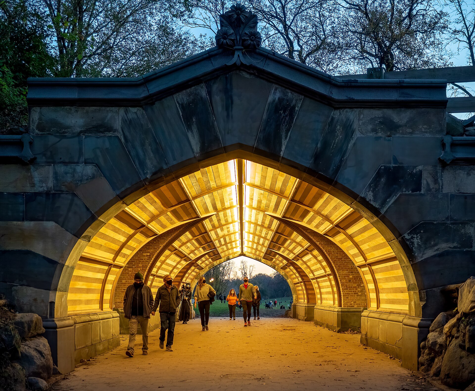 The glowing restored interior of Endale Arch, with walkers passing beneath its vaulted wooden ceiling