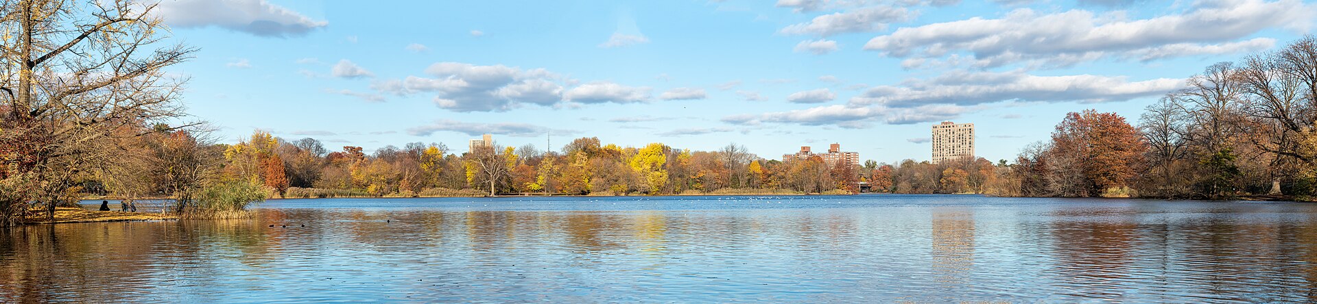 The park's lake in autumn, a wide sheet of water ringed by trees in fall color