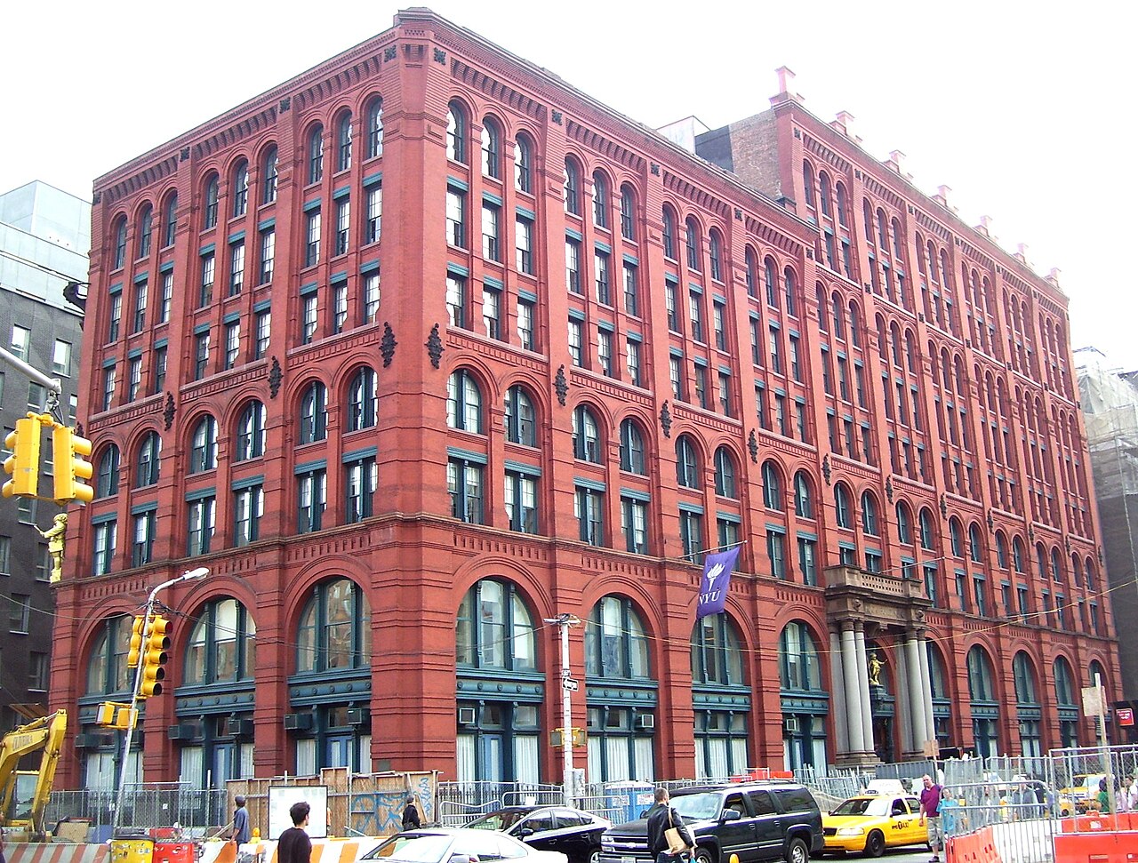 The Puck Building on Lafayette Street today, its red brick arches rising above Houston Street.