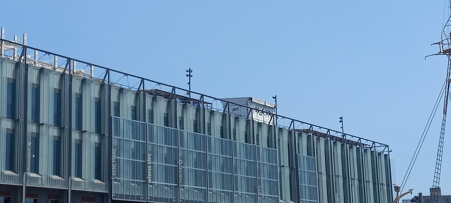 The rebuilt Pier 17, a low modern four-story building of glass and dark panels at the end of a pier over the East River