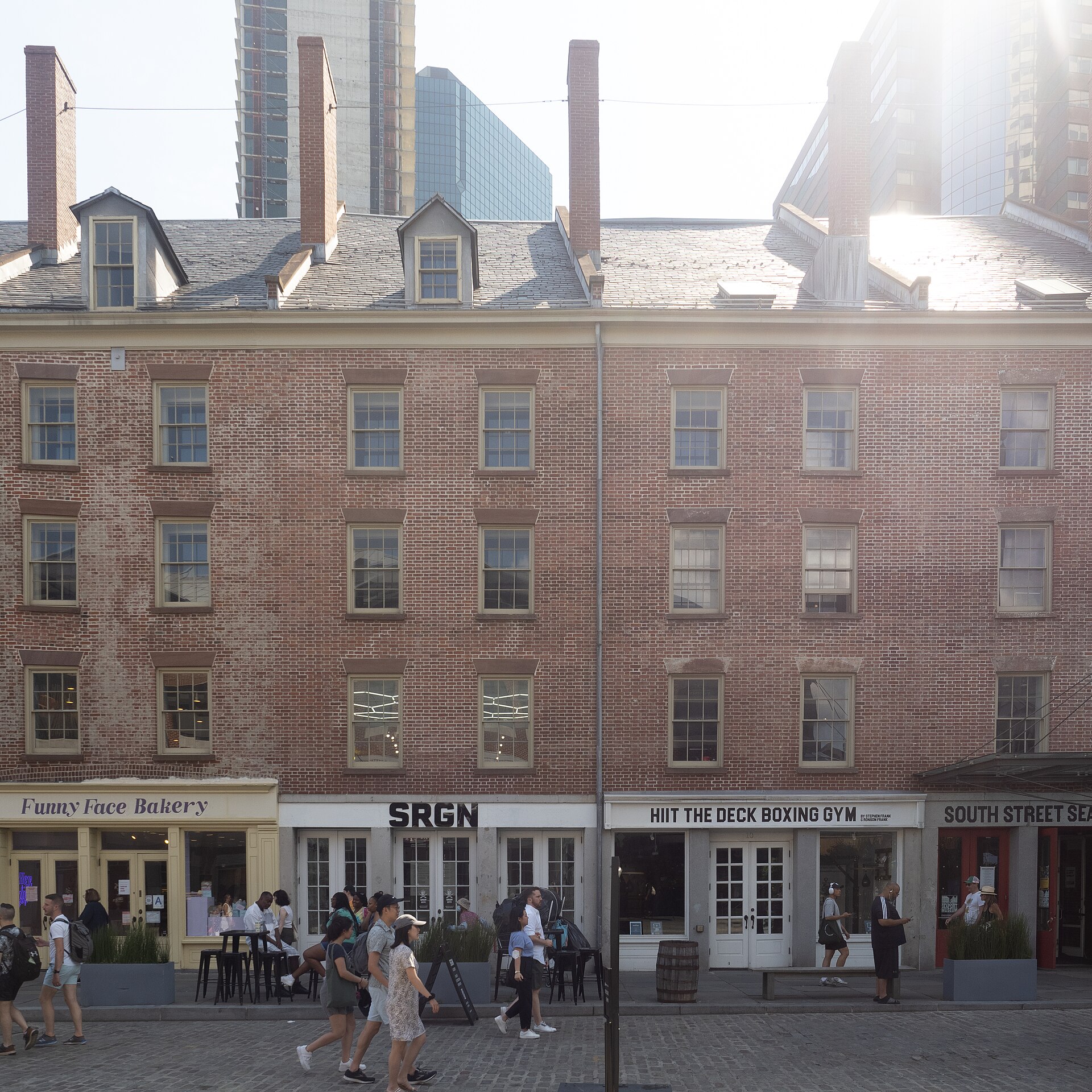 Schermerhorn Row in 2022, the row of low red-brick Federal-style counting houses with dormered roofs along Fulton Street