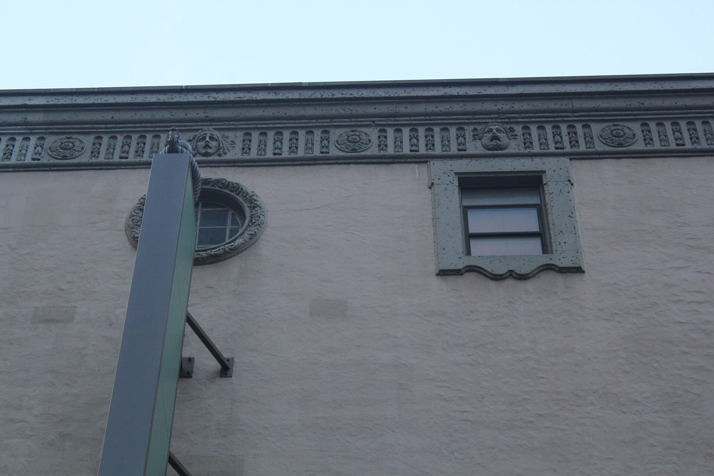 The cornice with theatrical masks and a bullseye window on the facade of the St. James Theatre in Manhattan