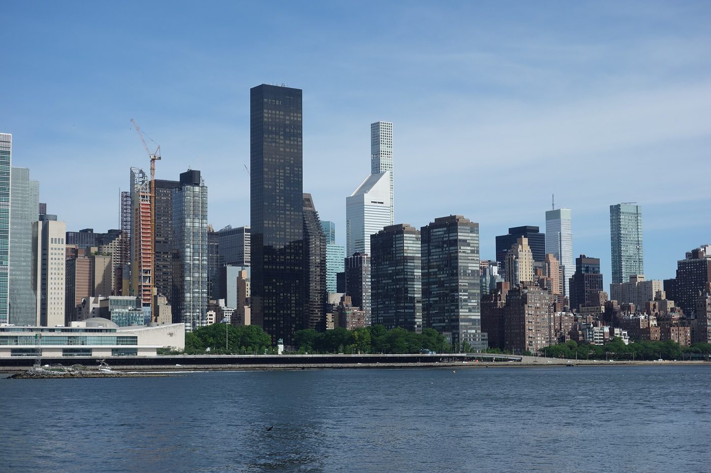 Trump World Tower standing among Midtown East towers on the Manhattan shore of the East River, viewed from Queens